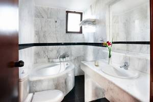 Badezimmer von Anna's House mit Badewanne, Waschbecken und Spiegel.