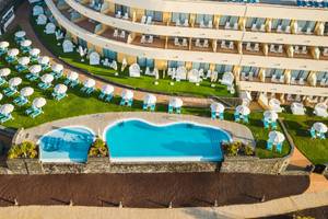 Luftaufnahme des Iberostar Playa Gaviotas Park Hotels mit Swimmingpool, Sonnenliegen und Sonnenschirmen.