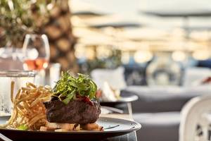 Grillsteak mit Beilagen auf der Terrasse im Mykonos Ammos Hotel