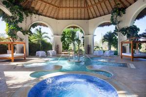 Poolbereich im Majestic Elegance Punta Cana Hotel mit überdachtem Bereich und mehreren Becken.
