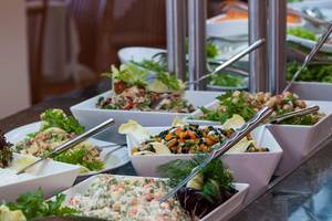 Buffet-Tisch im Apollo Beach Hotel mit verschiedenen Salaten und Gerichten.