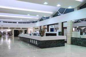 Empfangsbereich des Apollo Beach Hotels mit moderner Einrichtung und Marmor-Theke.
