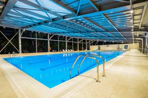 Innenpool des Apollo Beach Hotels mit blauem Wasser und Edelstahlhandläufen
