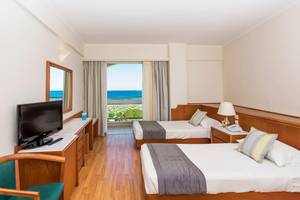 Doppelzimmer mit Meerblick im Apollo Beach Hotel mit zwei Betten, Fernseher und Balkon.