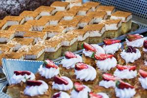 Eine Auswahl an verschiedenen Desserts im Apollo Beach Hotel, darunter Kuchen und Gebäck mit Sahne und Früchten.