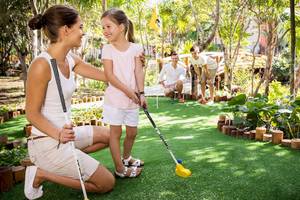 Eine Familie spielt Putt-Golf im Freien im Barcelo Maya Grand Resort.