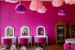 Friseursalon im Barcelo Maya Grand Resort mit pinken Wänden, Spiegeln, Stühlen und Lampen.