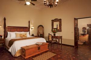 Zimmer im Dreams Tulum Resort & Spa mit Holzbett, Nachttischen, Dekor und Möbeln.