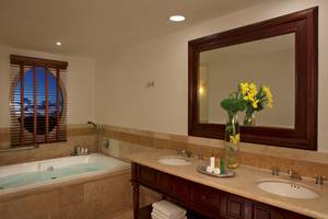 Badezimmer mit Badewanne, Spiegel und Blumenvase im Dreams Tulum Resort & Spa