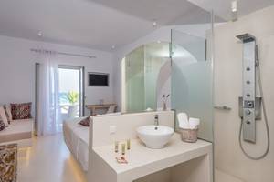 Badezimmer im Sunrise Mykonos Hotel mit modernem Design, Dusche und Badewanne.