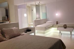 Schlafzimmer im Sunrise Mykonos Hotel mit weißen Möbeln und integrierten Beleuchtungselementen.