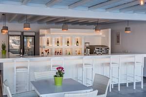 Barbereich im Sunrise Mykonos Hotel mit weißer Theke und Sitzgelegenheiten.