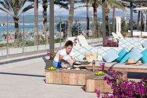 Ein Kellner serviert ein Essen auf der Terrasse des Universal Hotel Neptuno.