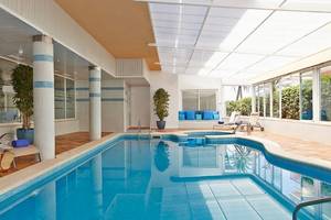 Innenpool im Universal Hotel Neptuno mit Loungebereich und Pflanzen.