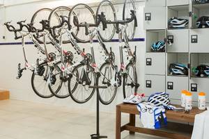 Ein Raum mit mehreren Fahrrädern an der Wand aufgehängt und Ausrüstung auf einem Tisch im Universal Hotel Neptuno.