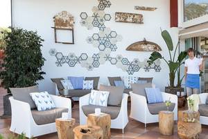 Empfangsbereich des Universal Hotel Neptuno mit modernen Möbeln und geometrischen Wanddekorationen.