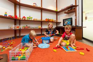 Kinder spielen im Spielzimmer des Dewa Phuket Resort mit Legos und anderen Spielzeugen.
