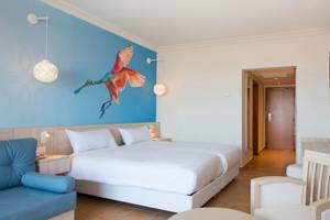 Doppelzimmer im Iberostar Founty Beach Hotel mit zwei Betten, blauer Wand und Vogelmalerei.