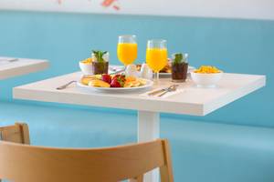 Frühstückstisch im Iberostar Founty Beach Hotel mit Früchten, Orangensaft und verschiedenen Getränken.