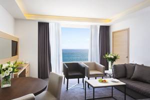 Innenansicht der Suite im Royal Apollonia Beach Hotel mit Blick auf das Meer.