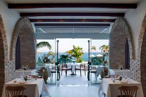 Innenansicht des Restaurants im Royal Apollonia Beach Hotel mit Blick auf das Meer.
