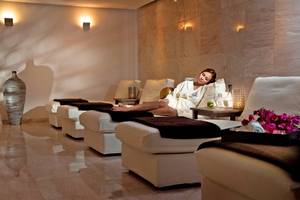 Spa-Lounge im Royal Apollonia Beach Hotel mit einer Frau im Bademantel