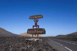 Schild des Nationalparks Timanfaya auf einem Felsen neben einer Straße