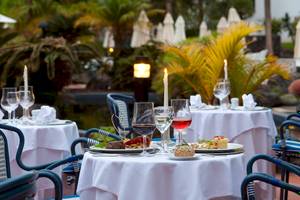 Restauranttisch im Freien im Seaside Los Jameos Hotel mit gedeckten Tischen und Gerichten.