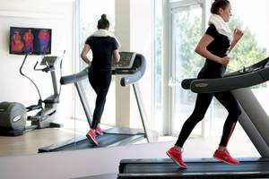 Zwei Frauen laufen auf einem Laufband im Fitnessstudio des Radisson Blu Resort Split.