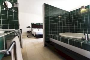 Ein Hotelzimmer mit einer Badewanne und einem Bett.
