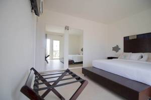 Ein modernes Hotelzimmer von Dunas De Sal mit weißem Bett und Spiegeln.
