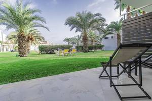 Gartenbereich des Dunas De Sal Hotels mit Palmen, Liegen und einem Tisch.