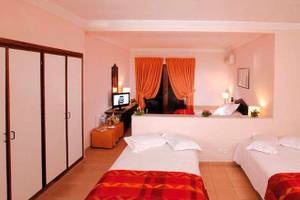 Doppelzimmer im Royal Decameron Issil Resort mit zwei Betten, Fernseher und Schrank.
