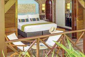 Schlafzimmer im Paradise Sun Hotel mit Zugang zum Balkon, inklusive Bett, Nachttischen und Stühle.