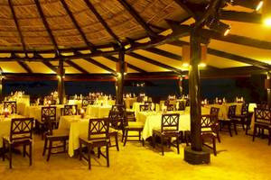 Restaurantbereich im Paradise Sun Hotel mit abendlicher Beleuchtung und gedeckten Tischen.