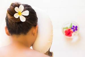 Rückenansicht einer Frau mit Blumenkranz im Hotel