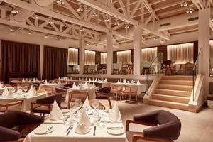 Innenansicht des Restaurants im Mare Ayia Napa Hotel mit gedeckten Tischen und Stühlen.
