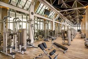 Fitnesscenter im Grand Hyatt Abu Dhabi Hotel mit vielen Trainingsgeräten und Spiegeln.