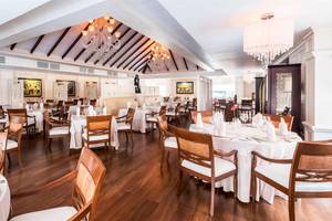 Innenansicht des Restaurants im Barcelo Bavaro Beach Hotel mit gedeckten Tischen und Stühlen.