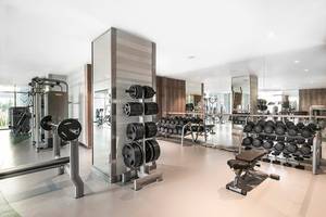 Fitnesscenter im Titanic Deluxe Lara Hotel mit verschiedenen Trainingsgeräten und Spiegeln.