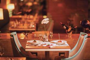 Tisch im Restaurant des Titanic Deluxe Lara mit dekorierten Tellern und Gläsern.