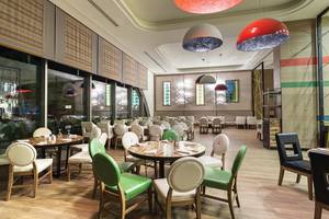 Innenbereich des Titanic Deluxe Lara Hotel Restaurants mit Holzboden, bunten Stühlen und Tischdecken.