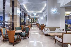 Hotellounge mit Sofas, Tischen und kunstvollen Kronleuchtern.
