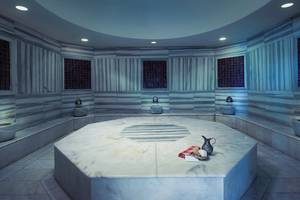 Dampfbad im Titanic Deluxe Lara Hotel mit Marmorwänden und Sitzbänken.