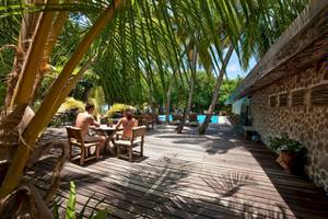 Paar sitzt am Tisch im Freibereich des Reethi Beach Resorts