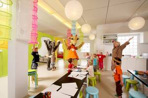 Kinder feiern im Hotel mit Animationsfiguren und haben Spaß.