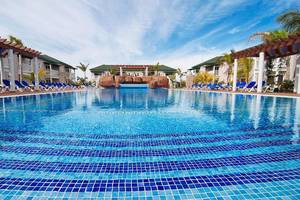 Schwimmbad des Valentin Varadero El Patriarca Hotels mit blauen Liegen und grünen Gebäuden