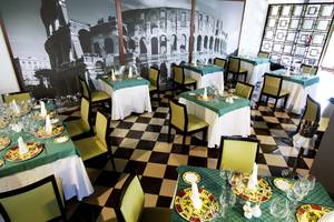 Innenansicht des Restaurants Valentin Varadero El Patriarca mit gedeckten Tischen und einem großen Wandbild des Kolosseums.
