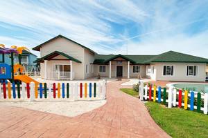 Außenansicht des Valentin Varadero El Patriarca Hotels mit buntem Spielplatz und Pool.