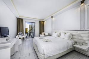 Ein elegantes Schlafzimmer im Diamond Deluxe Hotel mit einem großen Bett, weißem Dekor und moderner Einrichtung.